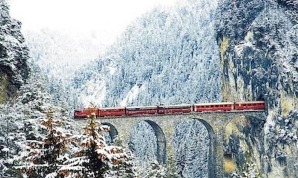 Zug der Schweizer Bahn überquert im Schnee den Landwasser viadukt