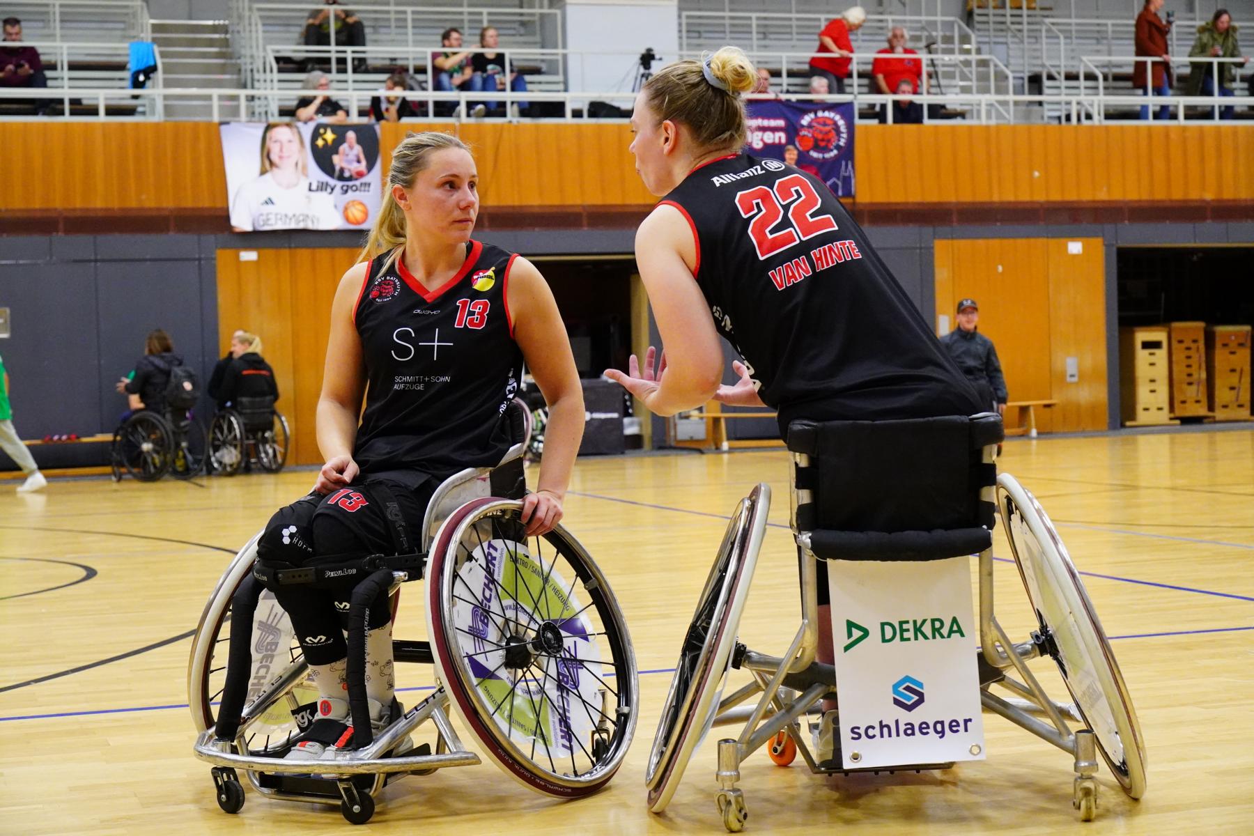 Zwei Frauen im Rollstuhl spielen Rollstuhlbasketball