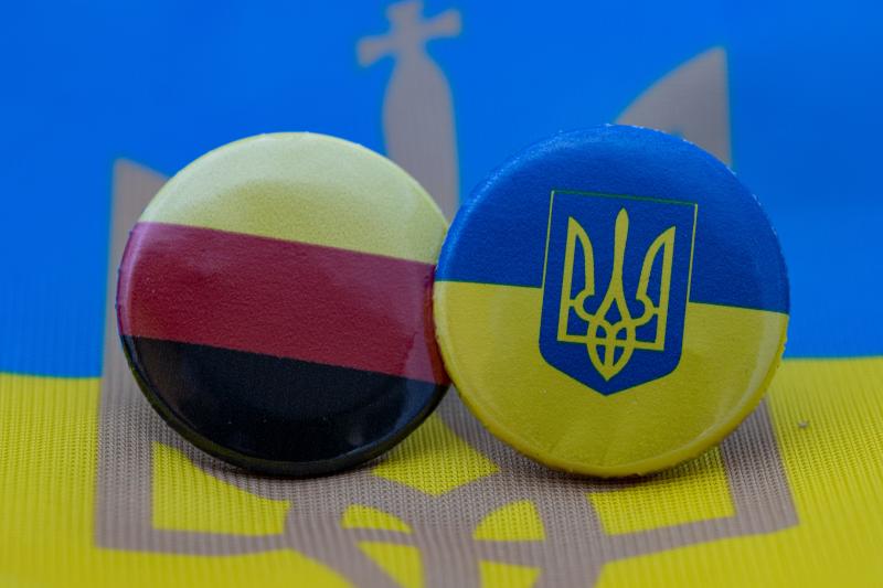 Bild Zeigt einen Button mit Deutscher Flagge / einen Button mit Ukrainischer Flagge liegen nebeneinander auf Flagge der Ukraine