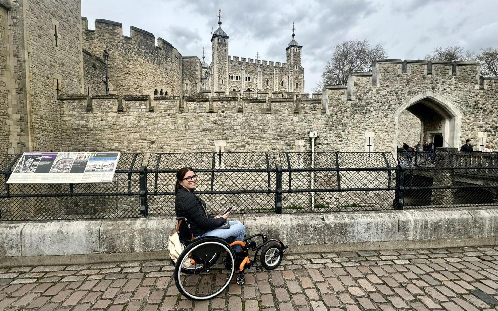 Roxana sitzt in ihrem Rollstuhl mit dem Vorspannrad. Im Hintergrund der Tower of London