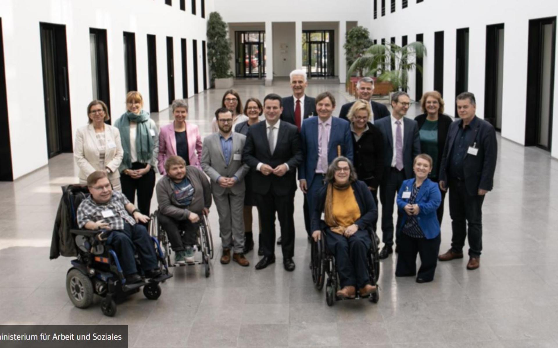 Bild zeigt eine Gruppe mit Menschen Stehend und im Rollstuhl in der Mitte Minister Hubertus Heil 