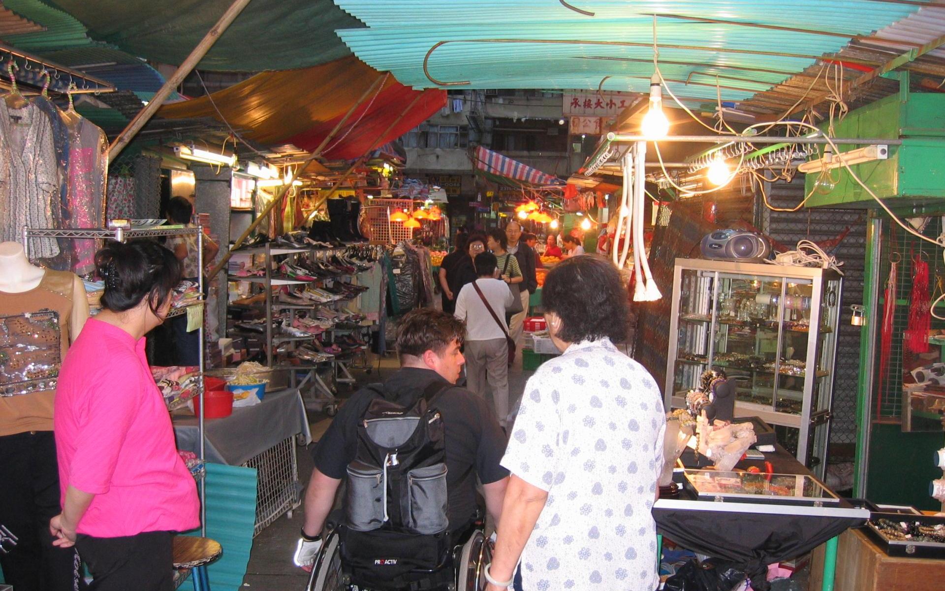 Rollstuhlfahrer auf einem engen Markt in Hong Kong