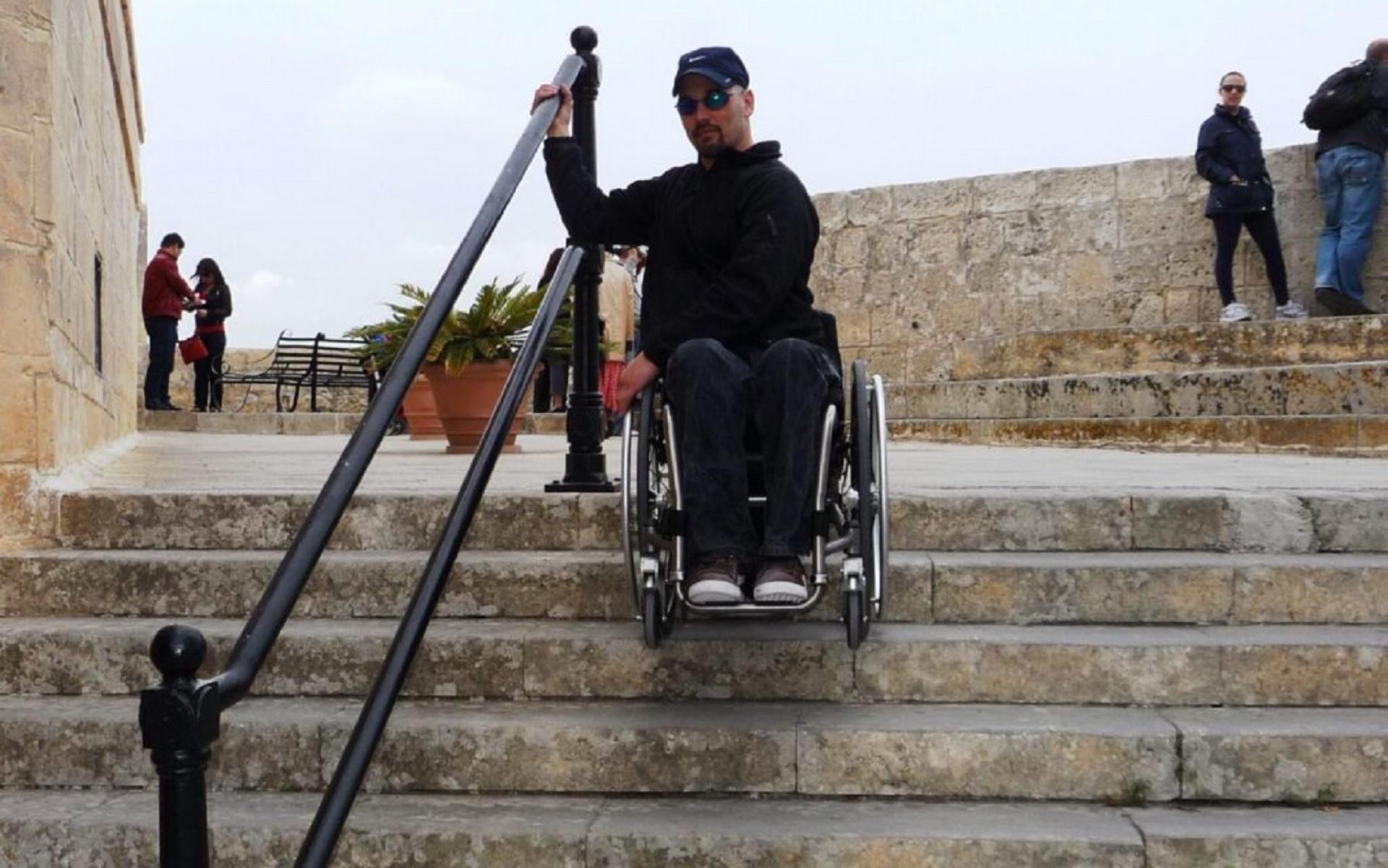 Der Autor Erik Kondo im Rollstuhl auf der Treppe