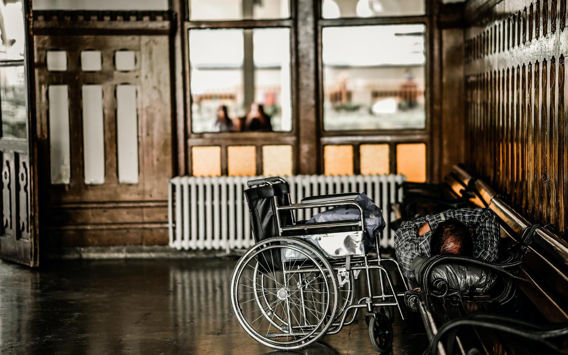 Rollstuhlfahrer liegt gemütlich auf einer Bank zu Hause