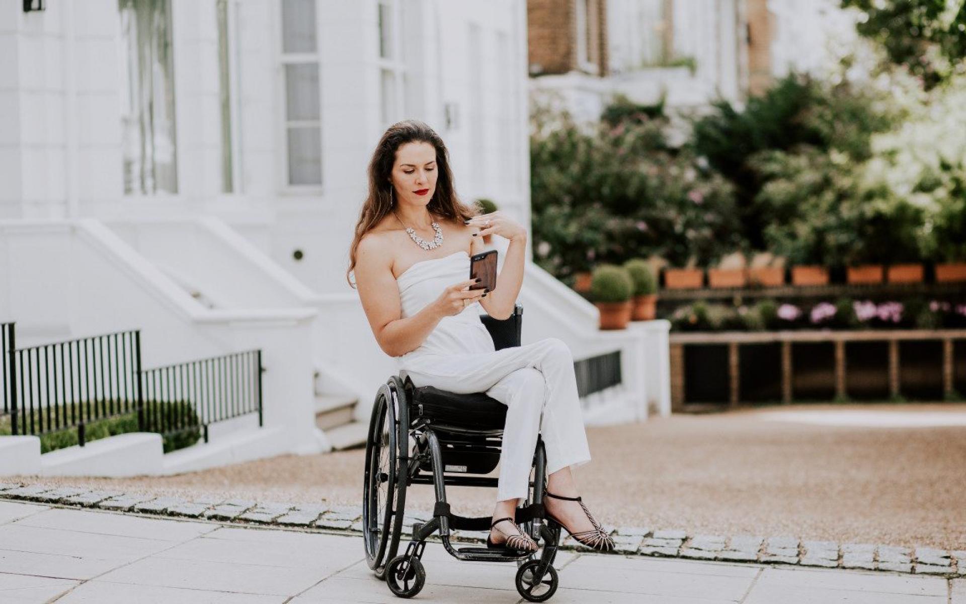 Bild zeigt Samanta Bullock im Rollstuhl auf das Hani blickend vor einer Häuserreihe in England