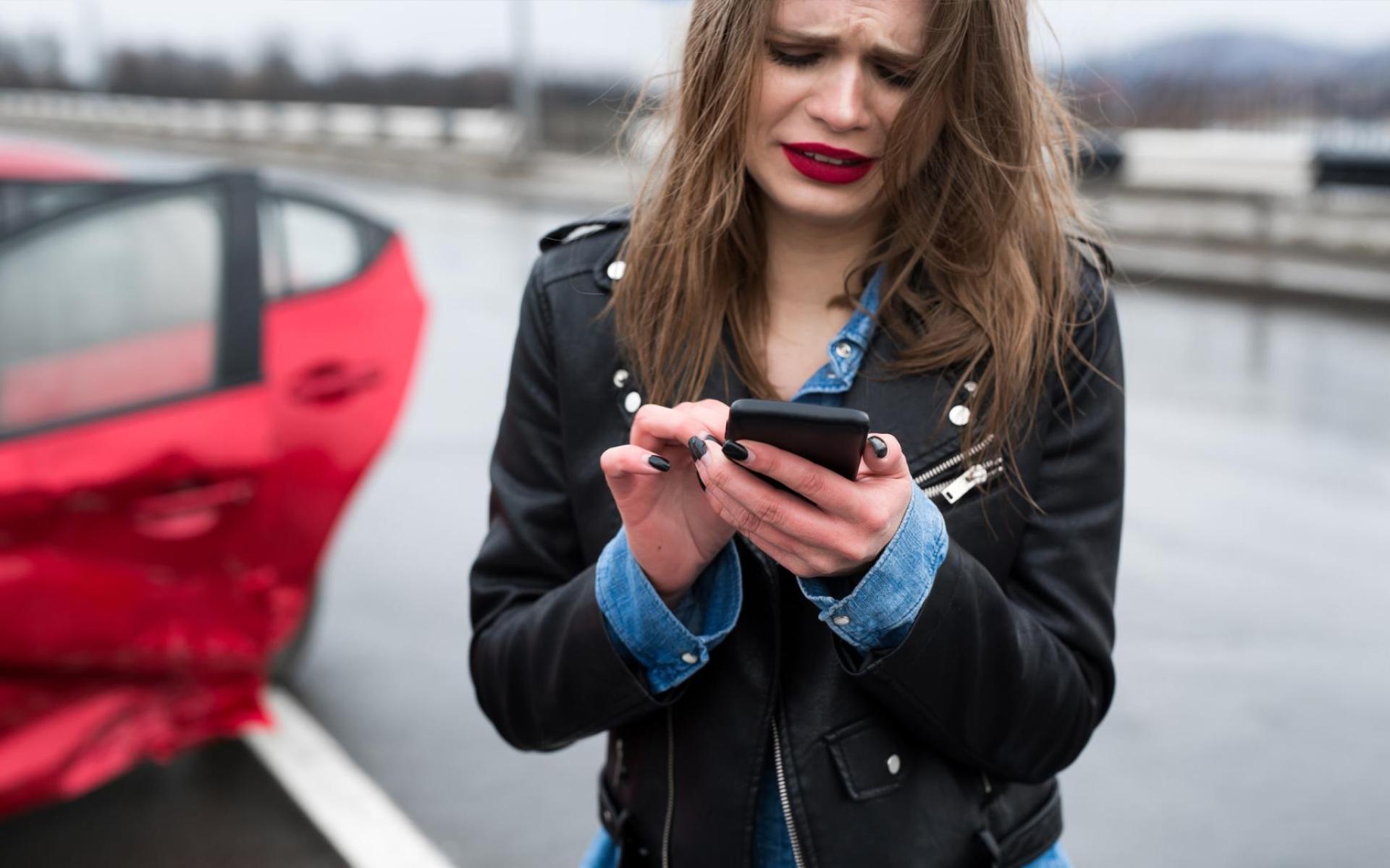 Frau nach Autounfall tuft Hilfe mit Mobiltelefon