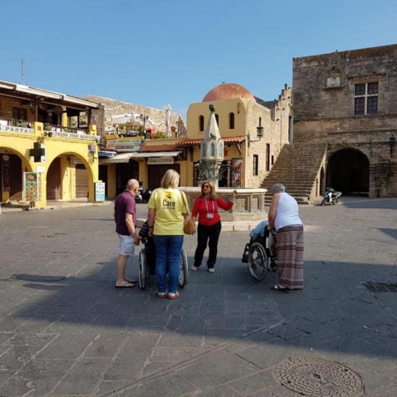 Eine Gruppe beim Ausflug in Rhodos Altstadt mit Teilnehmern im Rollstuhl. 