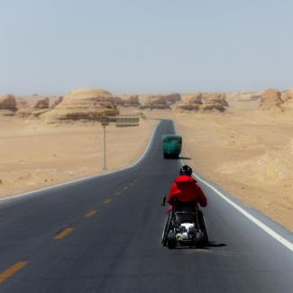 Anreas mit denm Handbike auf einer Wüstenstrasse