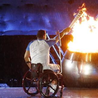 Rollstuhlfahrer am olympischen Feuer