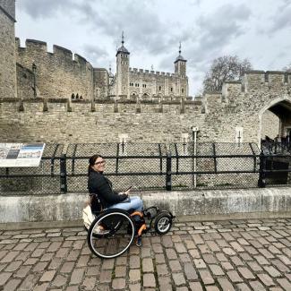 Roxana sitzt in ihrem Rollstuhl mit dem Vorspannrad. Im Hintergrund der Tower of London