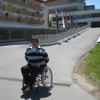 Alexander Lang im Rollstuhl vor dem Barrierfreien Hotel Aldiana Salzkammergut
